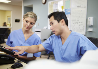 male and female nurse working at nurses station