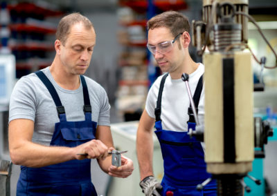 Two worker in factory on the machine