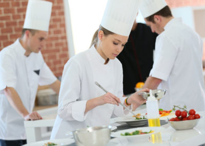 Girl in cooking training class preparing dish