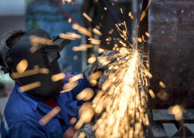 Electric wheel grinding on steel pipe in factory