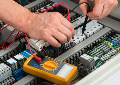 Close-up of a male electrician checking fuse with multimeter