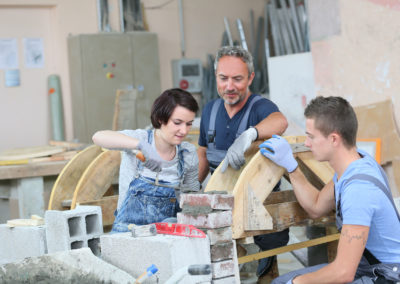 Instructor teaching students brick laying