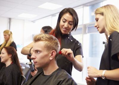 Teacher helping students training to become hairdressers