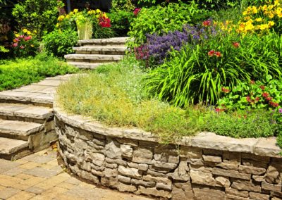 Natural stone landscaping in home garden with stairs and retaining walls